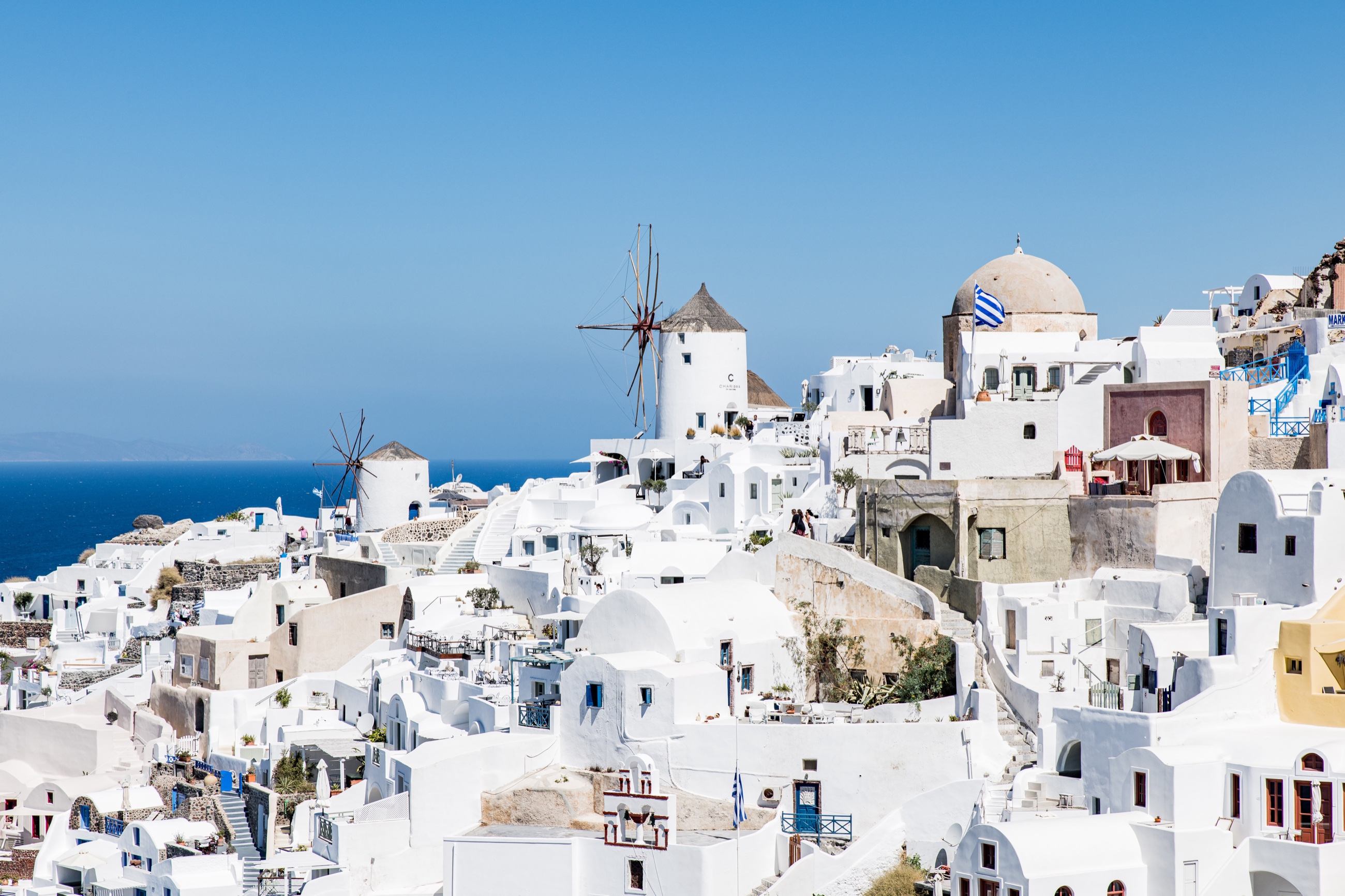 Whitewashed buildings, windmills, and blue sea in Santorini, Greece